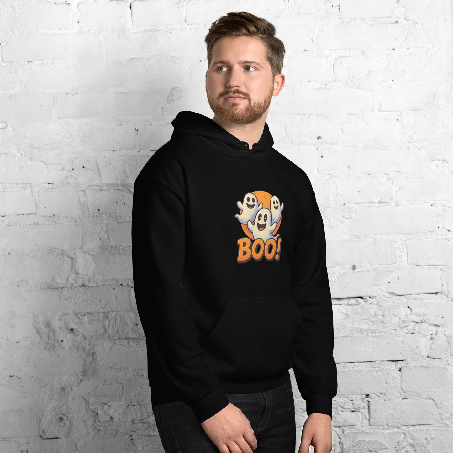 Man wearing a black hoodie with 'BOO!' design against a white brick wall