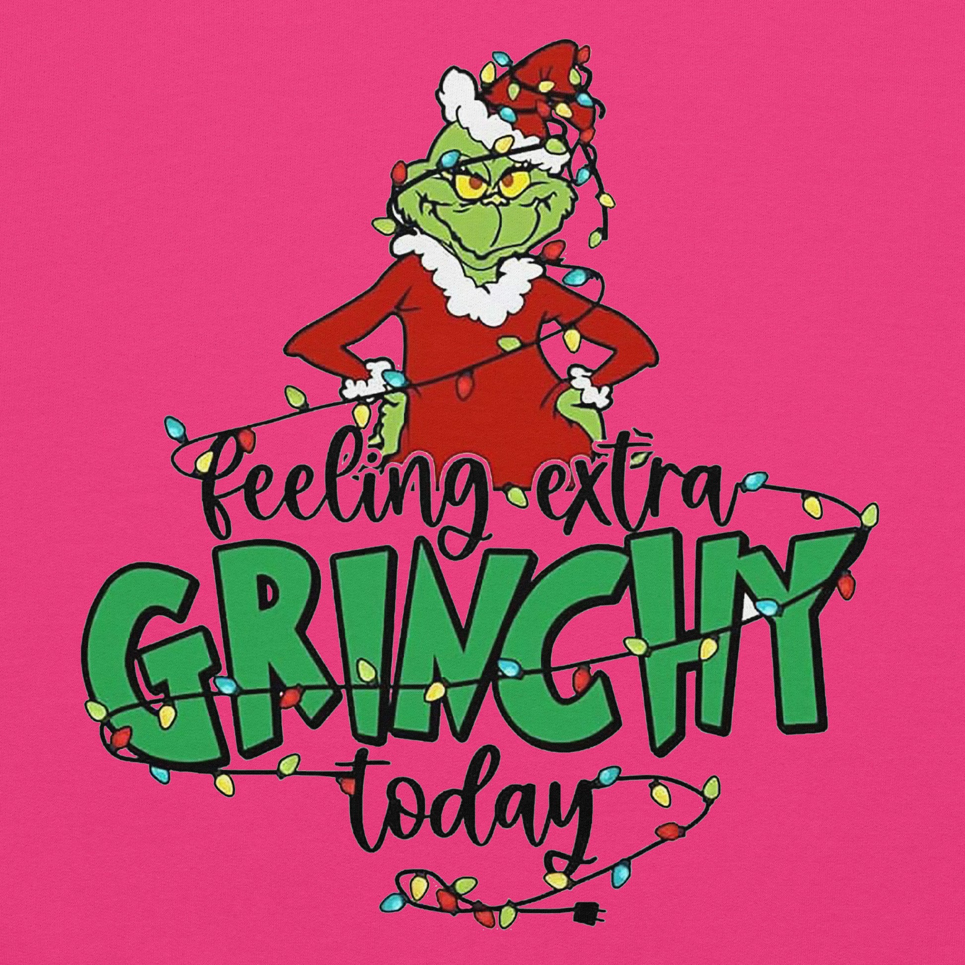 Cartoon character wearing a red suit with white fur trim and green hat, surrounded by Christmas lights on a pink background with text 'Feeling extra Grinchy today'.