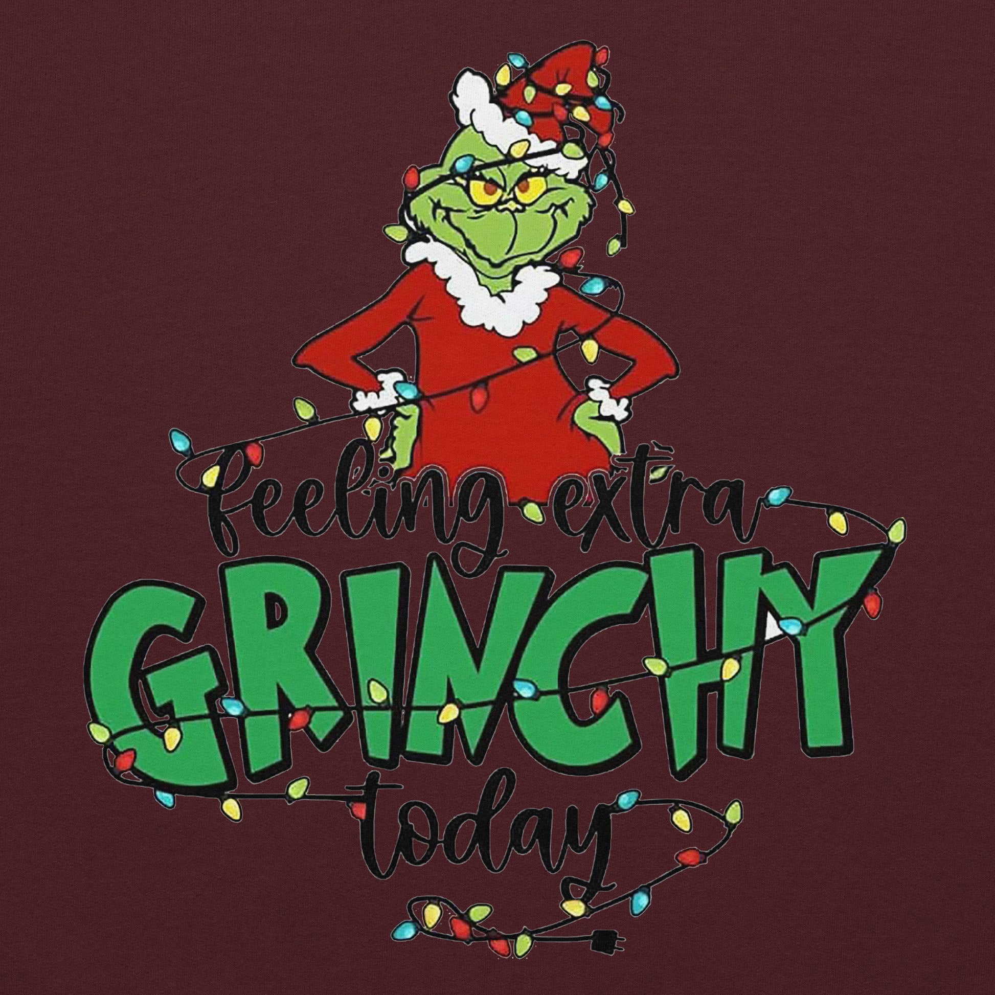 Grinch character with Christmas lights and text 'Feeling extra Grinchy today' on a dark red background