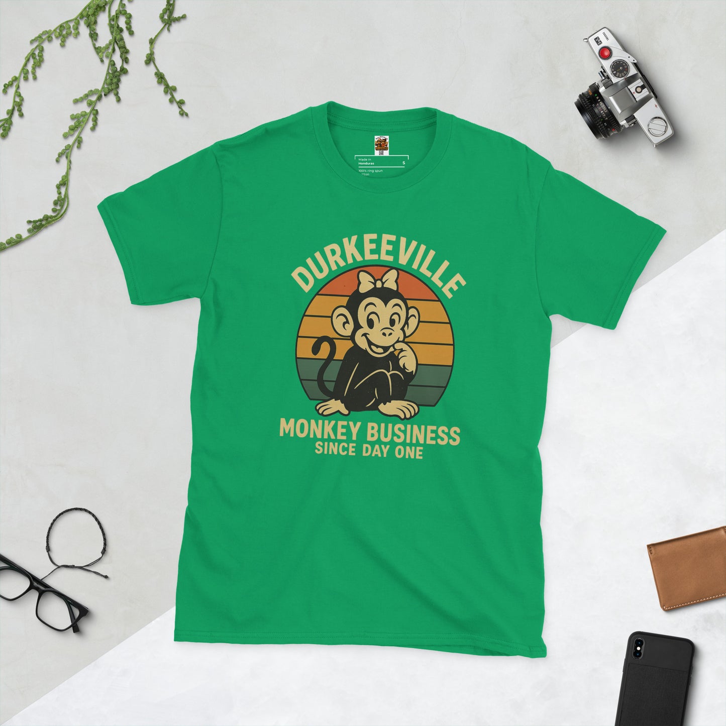 Green t-shirt with a monkey graphic and text on a light gray background