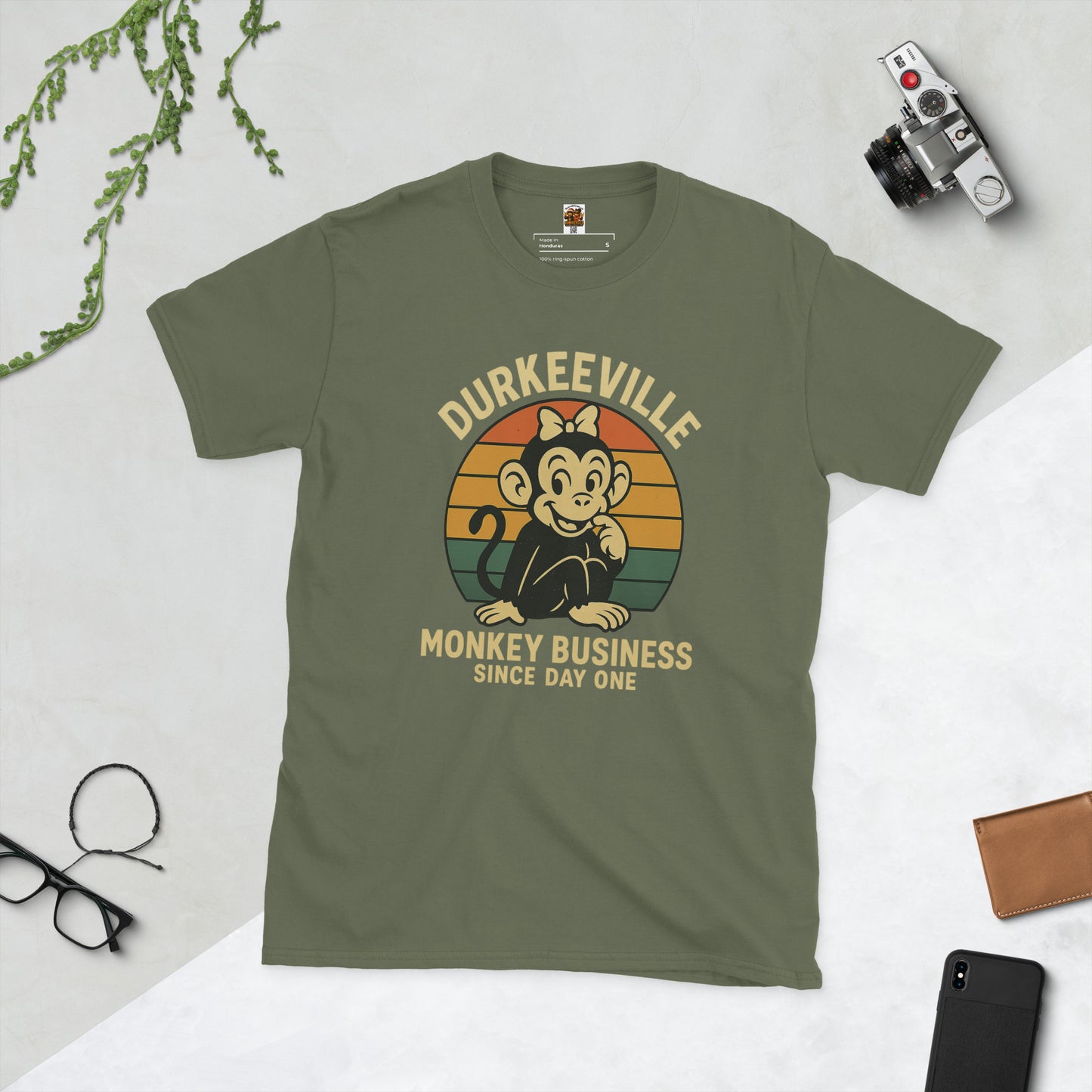 Green t-shirt with monkey graphic and text on a light gray background