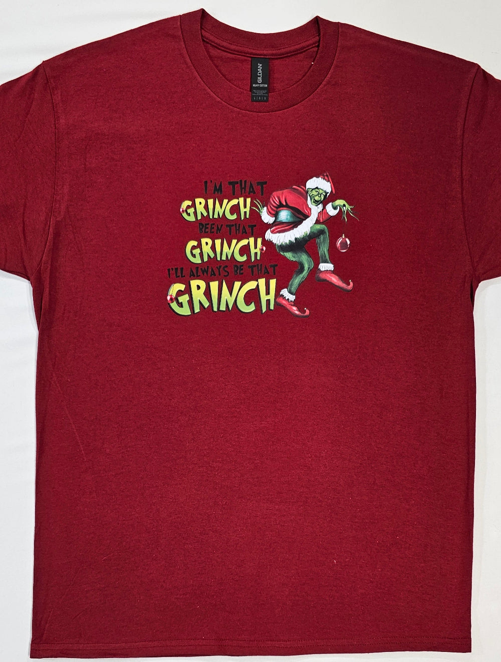 Red t-shirt with Grinch graphic and text on a white background