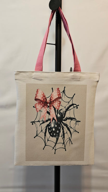 Small tote with spider design and pink bow on a white background