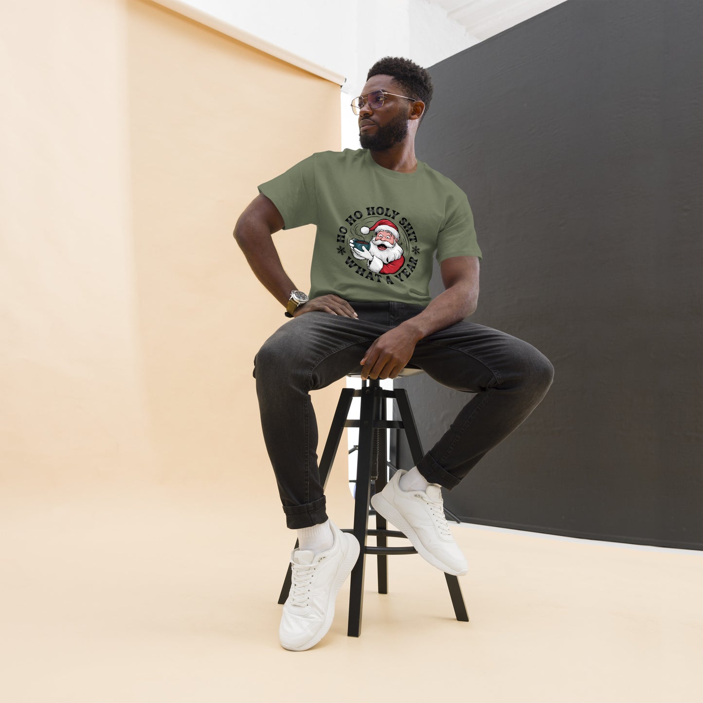 Man sitting on a stool wearing a green t-shirt with a graphic design.