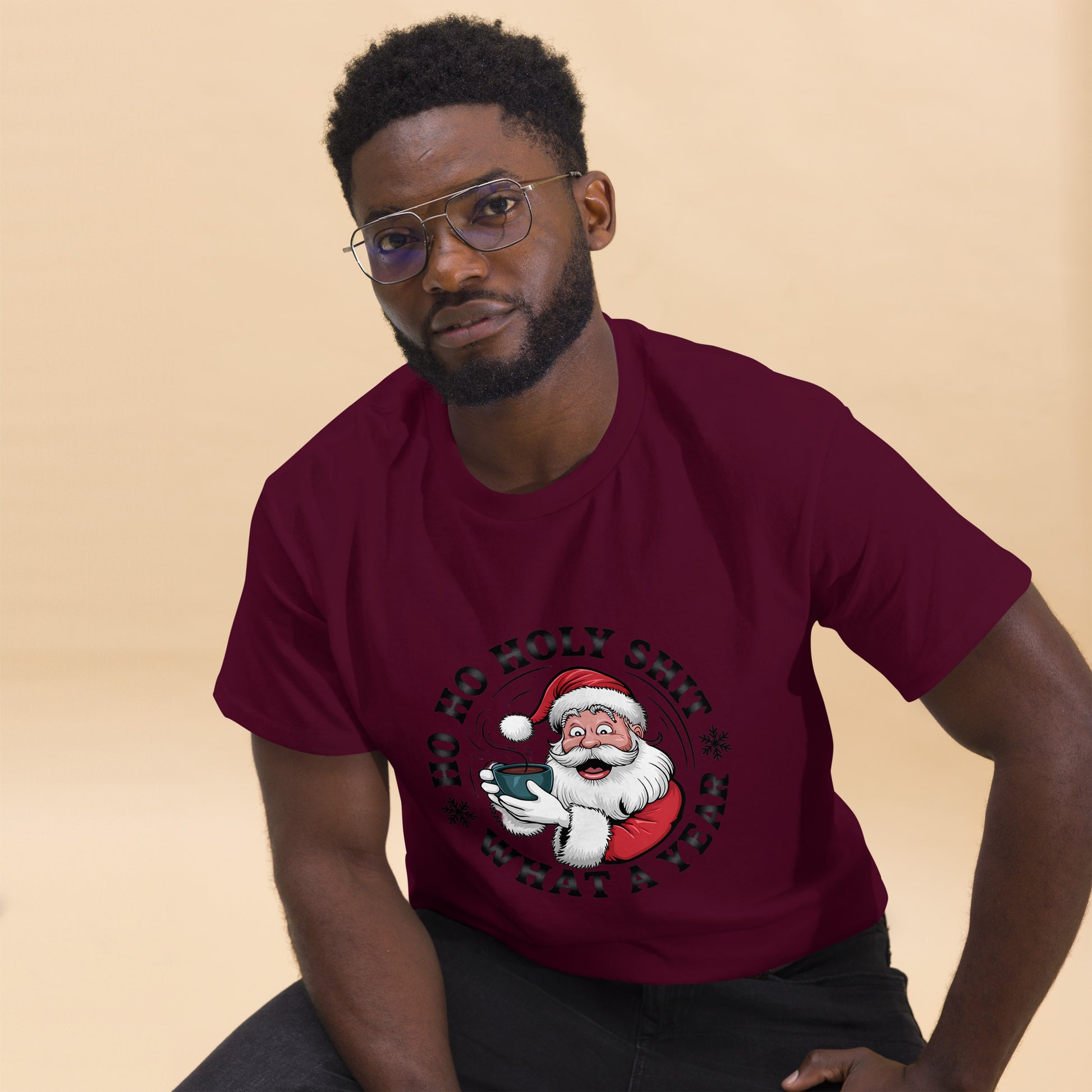 Man wearing a maroon t-shirt with a Christmas-themed graphic on a beige background