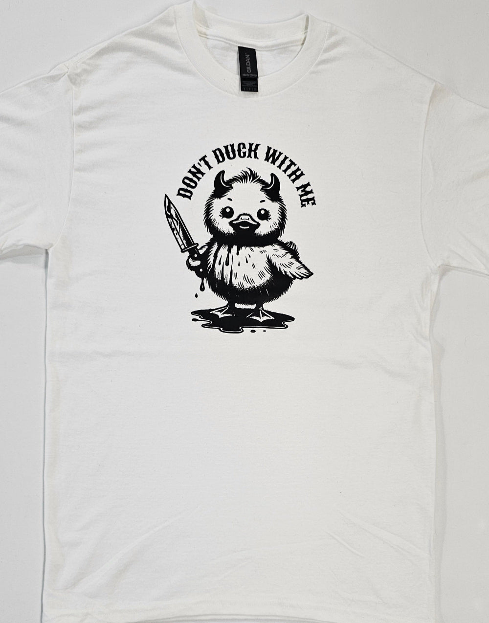 White t-shirt with a graphic of a duck holding a knife and text 'Don't Duck With Me' on a white background.