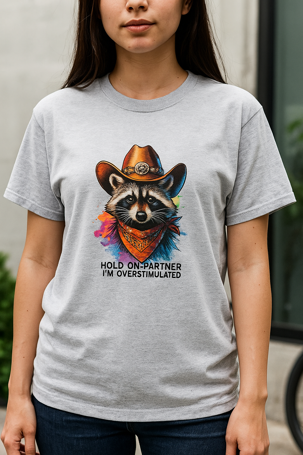 Person wearing a gray t-shirt with a raccoon graphic and text.