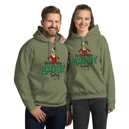 Two people wearing green 'Feeling extra Grinchy today' hoodies on a white background
