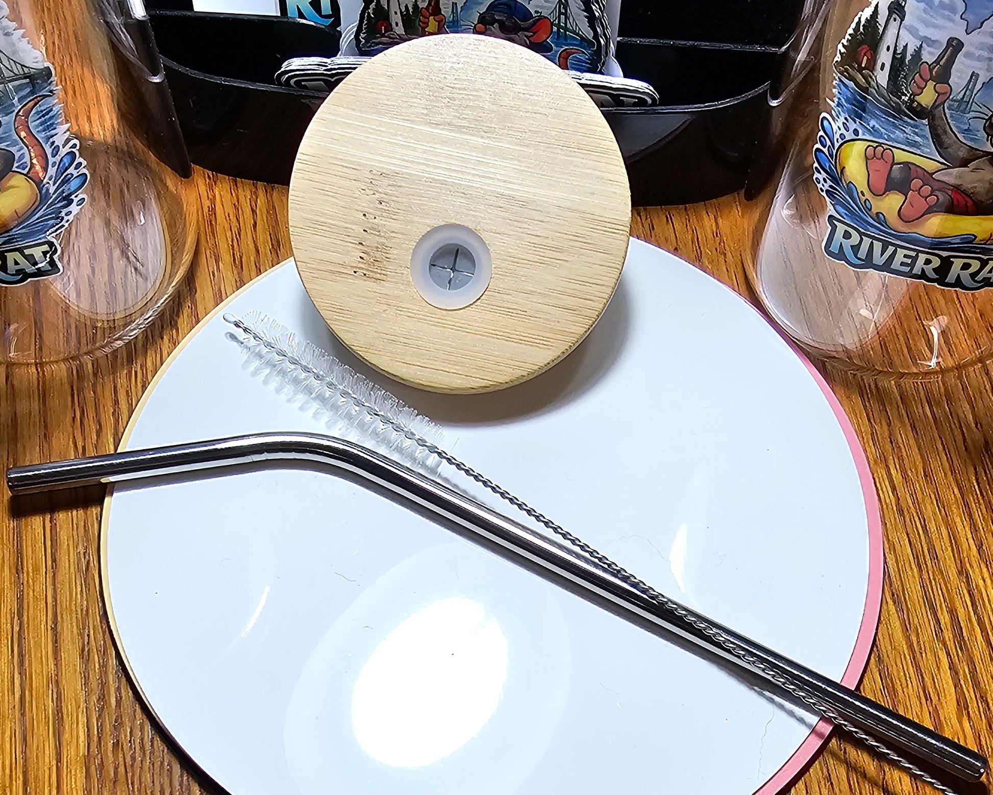 Close-up of a metal straw and a bamboo wooden lid.