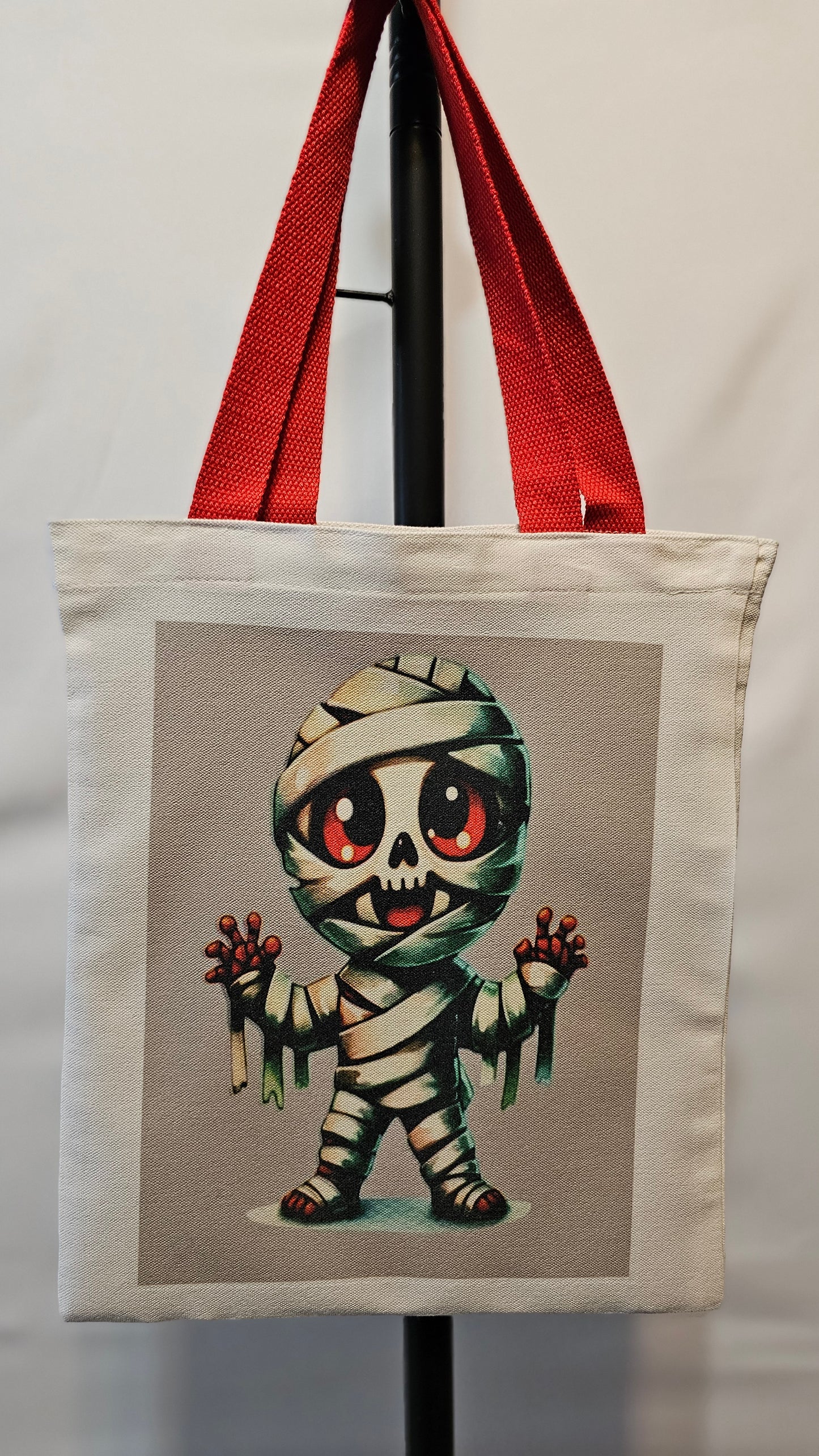 Decorative pillow with a cartoonish mummy design on a neutral background