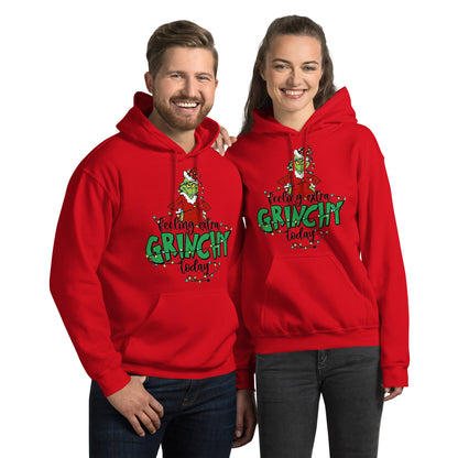 Two people wearing red 'Feeling extra Grinchy today' hoodies on a white background