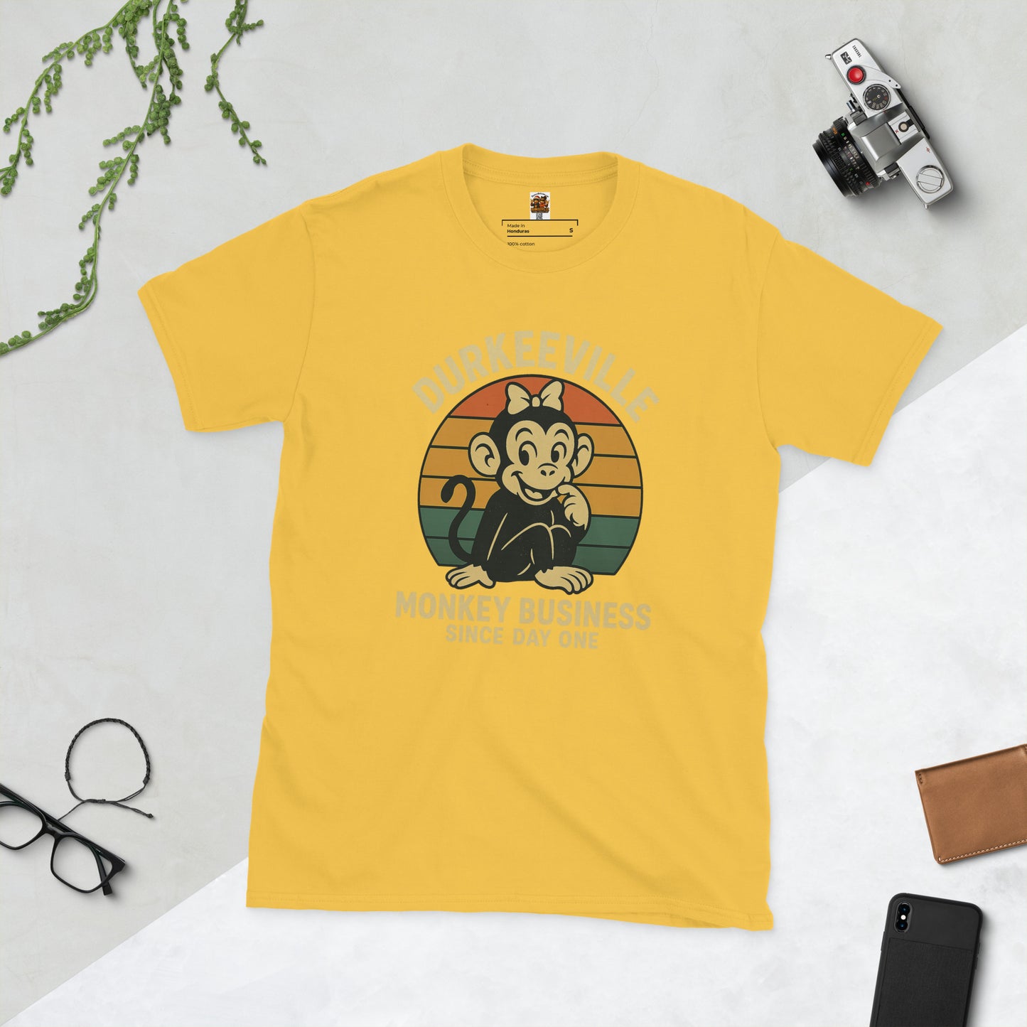 yellow t-shirt with a monkey graphic and text on a light gray background